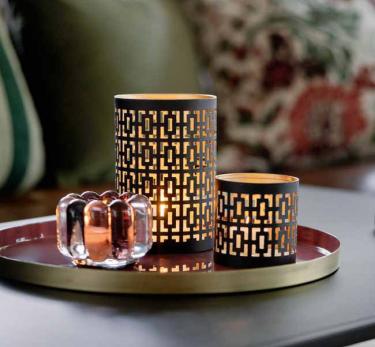 Ti dfor innekos med lune lys og høstfargede puter i sofaen