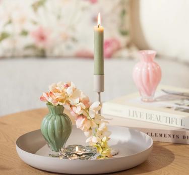 Lysfat med lys og blomst i vase