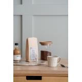 kopp iben på kjøkkenbenk med kaffe og kaffesirup