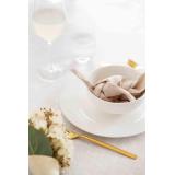 Serviett i skål på dekt bord med blomster