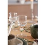 Glass med blomster detaljer dekt på fargerikt bord