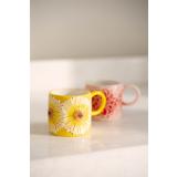 Kopp solsikke og peon på kjøkkenbenk