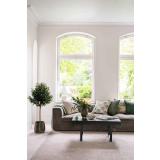 Stuemiljø med sofabord, puter og grønne planter