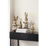 Harer i strå i fire ulike varianter stående på konsollbord som påskepynt