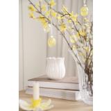 Liten tulipan vase på bord med gåsunger, glassegg og lysestake