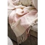 Rosa pledd liggende i sofa