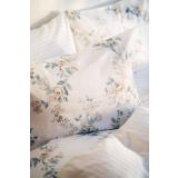 Satengsett med blomster motiv og i hvitt i seng