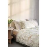 Satengsengesett med blomster og i hvitt på seng