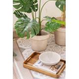 Serveringsbrett med dekorskål og utepotte på uteteppe på balkong