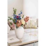 Frodig blomsterbukett i vase alba på sofabord