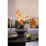 Vase, med blader og nyper på bord med dekoreple og lysestake