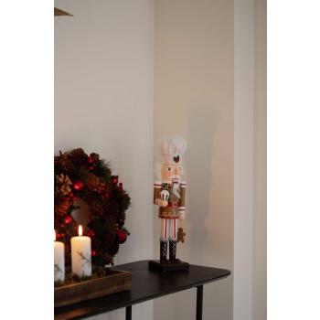 Nøtteknekker på konsollbord med lysfat stylet som adventsstake