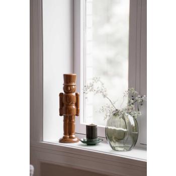 Nøtteknekker i vinduskarm med lys og vase