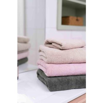 Håndklesett i beige, rosa og grønn på baderom