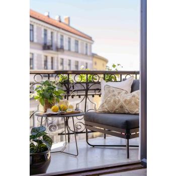 Balkong med puter, potter og servering