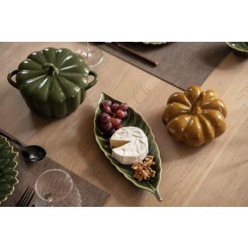 Servering på fat leaves på bord med ildfastform gresskar og gresskarfigur