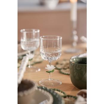 Glass med blomster detaljer dekt på fargerikt bord