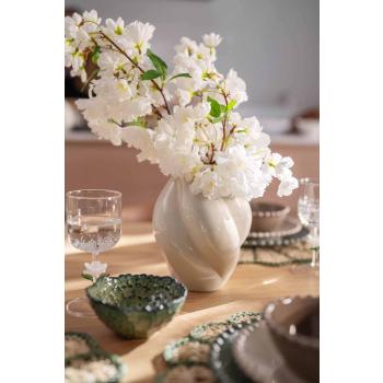 Vase med blomster på dekt middagsbord