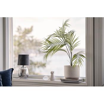 kunstig plante palme i potteskjuler i vinduskarm
