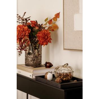 Konsollbord med krukke gresskar, glassfigur pinnsvin og kongle på lysfat og en vase med blomster