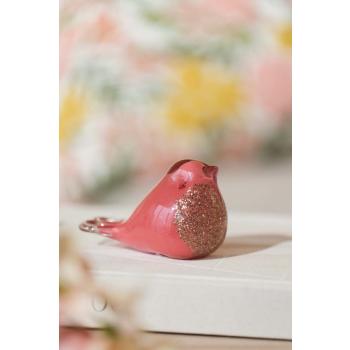 Glassfigur fugl i rosa på dekorbok