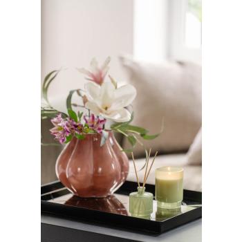 Bukett i rosa vase på lysfat med duftpinner og lys