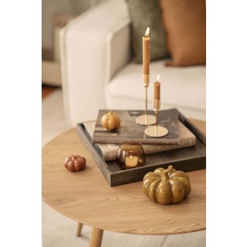 Lysfat med lysestaker og gresskar på sofabord