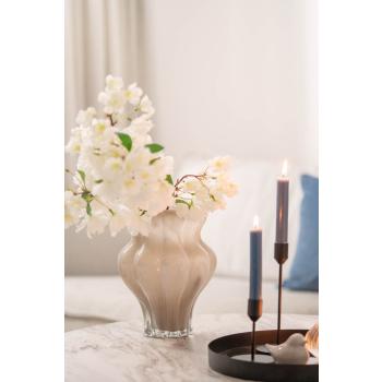 Vase med blomster og lysfat og lysestaker på bord