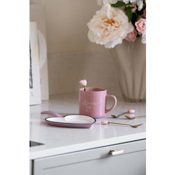 Stekepanne hjerte, med teskjeer med hjerte og rosa kopp på kjøkkenbenk