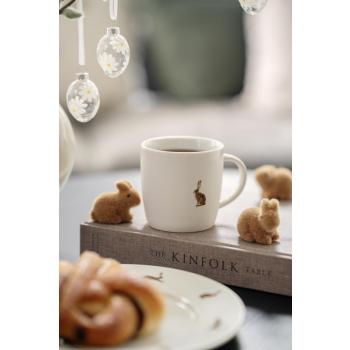 Kopp med haremotiv stående sammen med små kanindekorasjoner