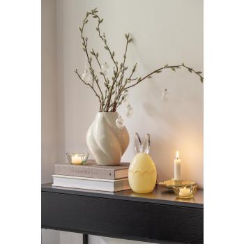 Konsollbord pyntet med vase, lysestake, telysholder og påskeskål