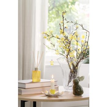 Vase, kaninfigur, kronelysestake og romduft på sofabord