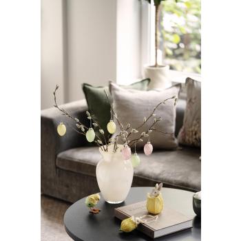 Gåsunger i vase med glassegg på sofabord med påskepynt