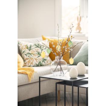 Dekoregg hvite på bord sammen med vase pyntet med grener og påskeegg