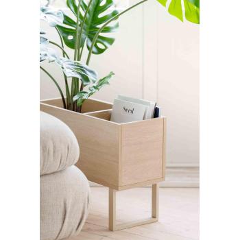 Baldkasse stående ved siden av sofa med grønn plante og blader