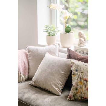 Putetrekk i sofa i ulike teksturer i rosa, beige og brune farger