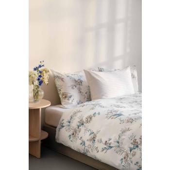 Satengsett med blomster motiv og i hvitt i seng